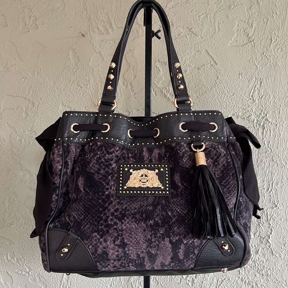 Juicy couture satchel with gold trim, black ribbon and velour snake print.